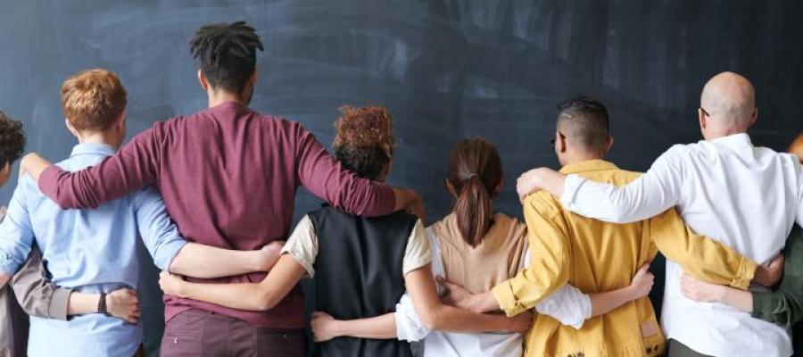 Five people from the back linking each other by shoulders and waists